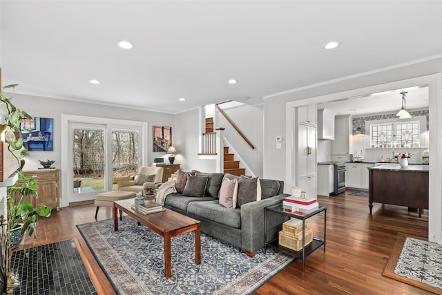 living room featuring dark hardwood / wood-style flooring, crown molding, and a healthy amount of sunlight