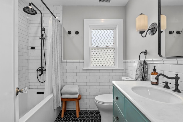 full bathroom featuring tile walls, vanity, toilet, tile patterned floors, and shower / bath combo with shower curtain