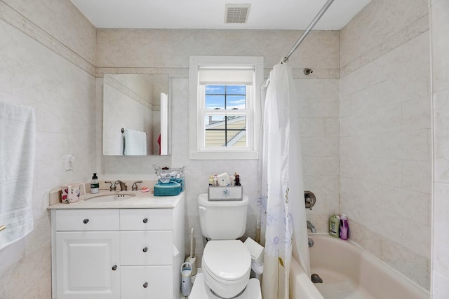 full bathroom featuring vanity, toilet, tile walls, and shower / bath combo