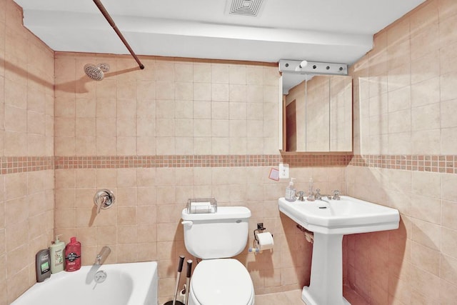 bathroom featuring tile walls, toilet, and tiled shower / bath