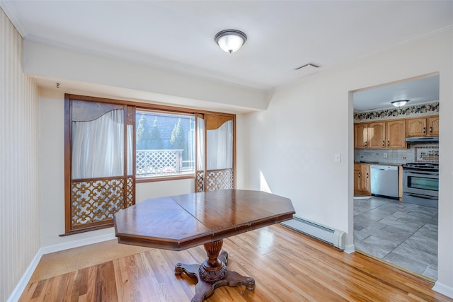 unfurnished dining area featuring light hardwood / wood-style floors and baseboard heating