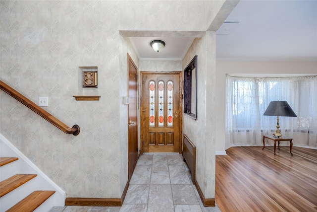 entrance foyer with crown molding and light hardwood / wood-style flooring