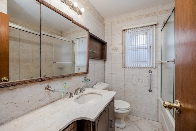 full bathroom featuring tile walls, vanity, tile patterned floors, and toilet