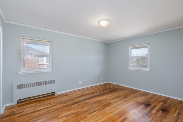 unfurnished room with crown molding, radiator heating unit, and hardwood / wood-style floors