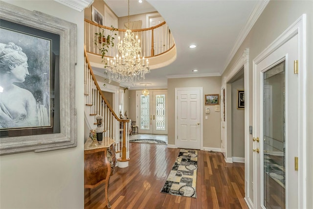 foyer with crown molding, dark wood-type flooring, an inviting chandelier, and french doors