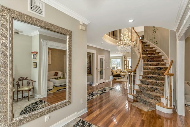 foyer entrance featuring crown molding, a chandelier, and hardwood / wood-style floors