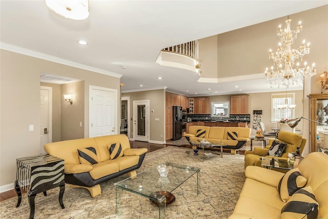 living room with recessed lighting, baseboards, ornamental molding, light wood-type flooring, and an inviting chandelier