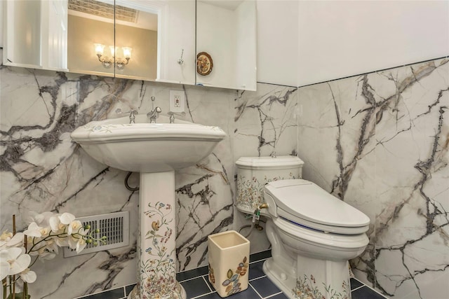 bathroom featuring an inviting chandelier and toilet