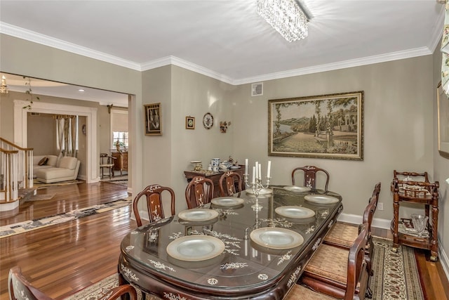 dining space featuring ornamental molding, wood finished floors, visible vents, and baseboards