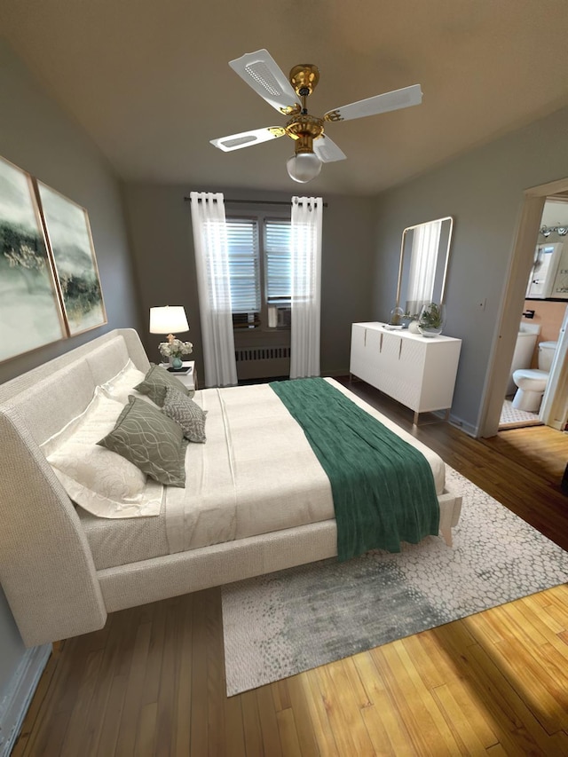 bedroom featuring ceiling fan, radiator heating unit, and wood-type flooring