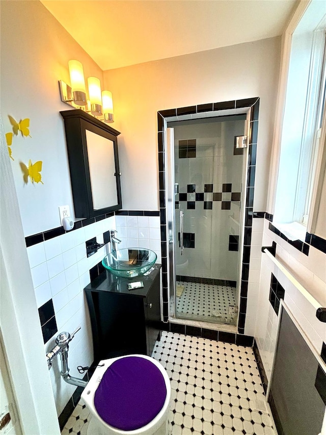 bathroom featuring tile patterned floors, vanity, an enclosed shower, and tile walls