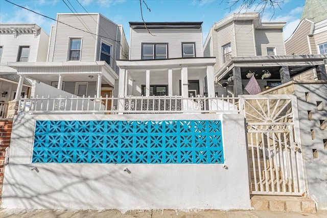 rear view of property featuring covered porch