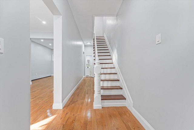 staircase featuring a baseboard radiator and hardwood / wood-style floors