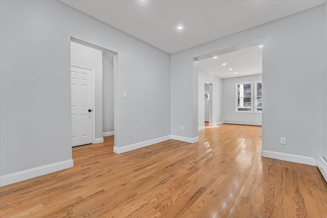 empty room with a baseboard heating unit and light wood-type flooring