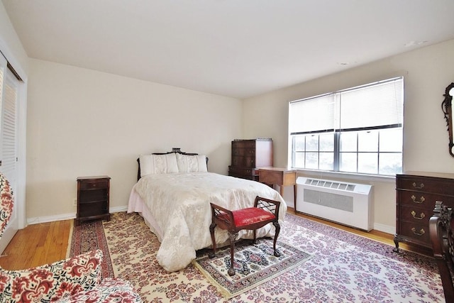 bedroom featuring radiator and light hardwood / wood-style floors