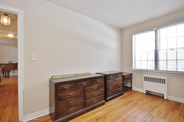 bedroom featuring radiator heating unit and light hardwood / wood-style floors