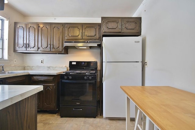 kitchen with butcher block counters, sink, white fridge, light tile patterned floors, and black gas range