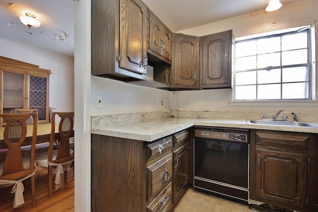 kitchen featuring dark brown cabinetry, sink, and black dishwasher