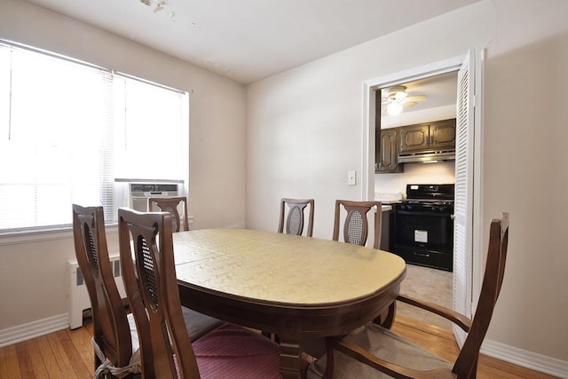 dining room with cooling unit, light hardwood / wood-style flooring, and ceiling fan