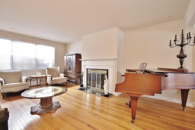 sitting room with wood-type flooring and ornamental molding