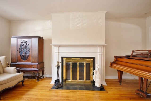 living area with ornamental molding and wood-type flooring