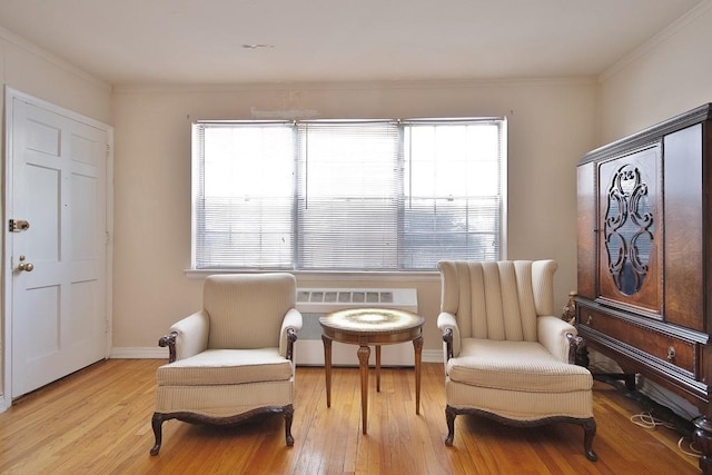 living area featuring ornamental molding, light hardwood / wood-style flooring, and a wealth of natural light