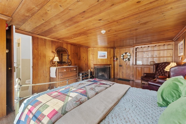 bedroom with wood walls, wood ceiling, a fireplace, and wood finished floors