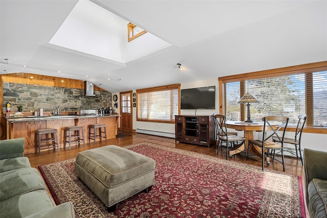 living room featuring lofted ceiling, a baseboard radiator, and wood finished floors