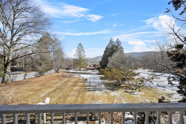 yard covered in snow featuring a mountain view