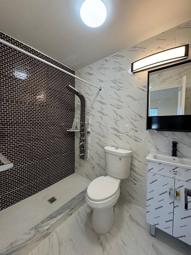 bathroom featuring tiled shower, vanity, toilet, and tile walls