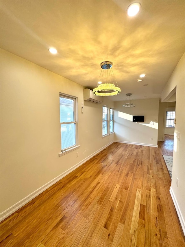 spare room with light hardwood / wood-style flooring and a wall mounted AC