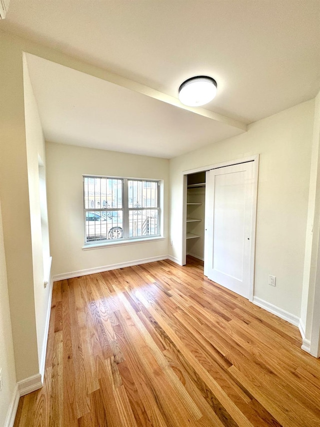 unfurnished bedroom featuring a closet and light wood-type flooring