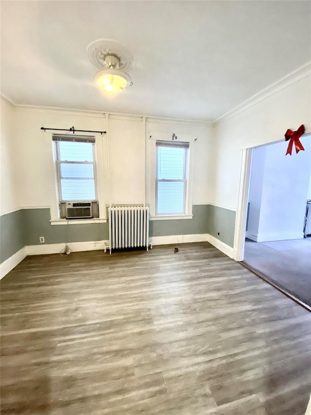 empty room with radiator, ornamental molding, and hardwood / wood-style floors