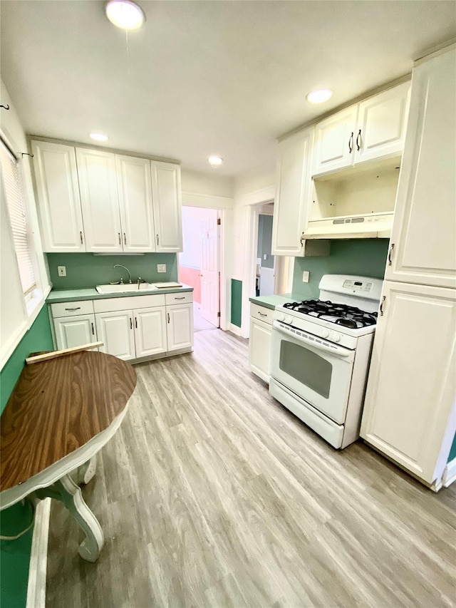 kitchen featuring white cabinetry, white range with gas cooktop, and sink