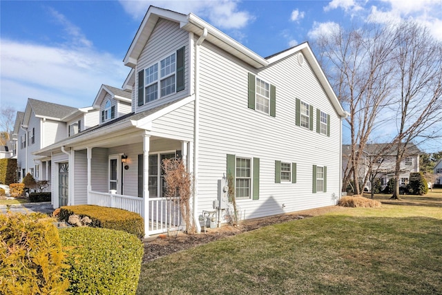 view of side of home featuring a yard and covered porch