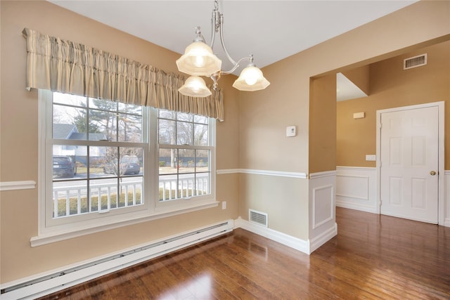 spare room with a baseboard heating unit and dark wood-type flooring