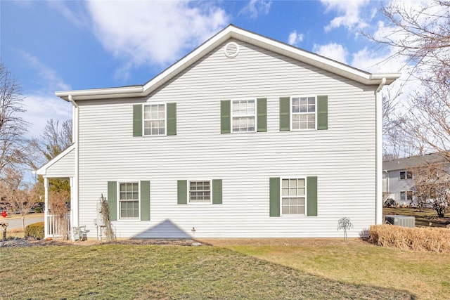 back of house featuring central AC unit and a lawn