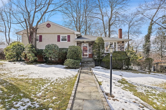 view of front of home featuring stone siding and a chimney