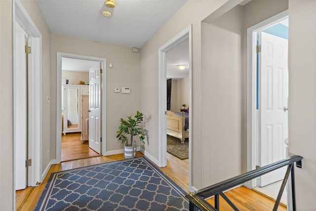 corridor featuring baseboards and wood finished floors