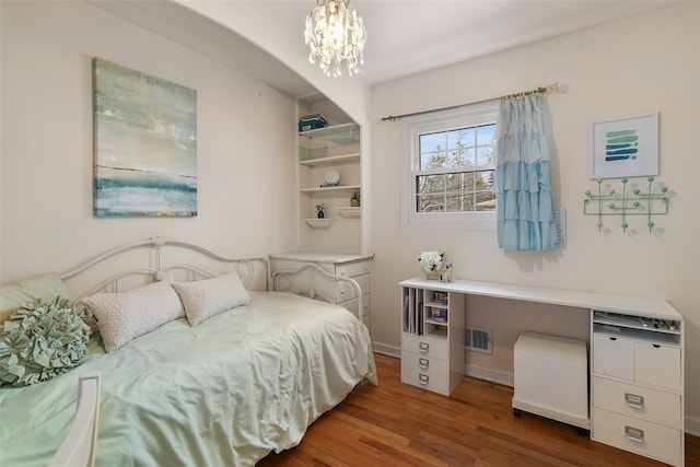 bedroom featuring baseboards, dark wood finished floors, visible vents, and a notable chandelier