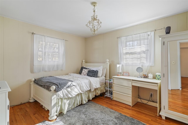 bedroom featuring a chandelier and wood finished floors