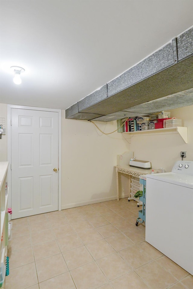 clothes washing area featuring washer / dryer, tile patterned flooring, laundry area, and baseboards