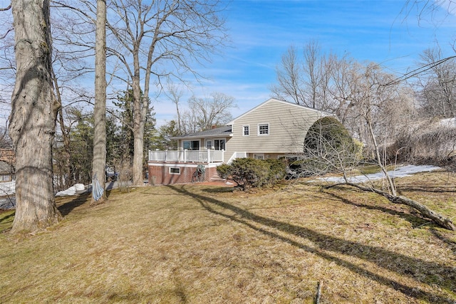 rear view of house with a porch and a lawn