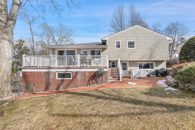 rear view of property with brick siding, a yard, a patio, stairway, and a deck