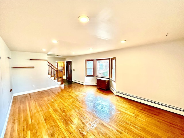 spare room featuring hardwood / wood-style flooring and baseboard heating