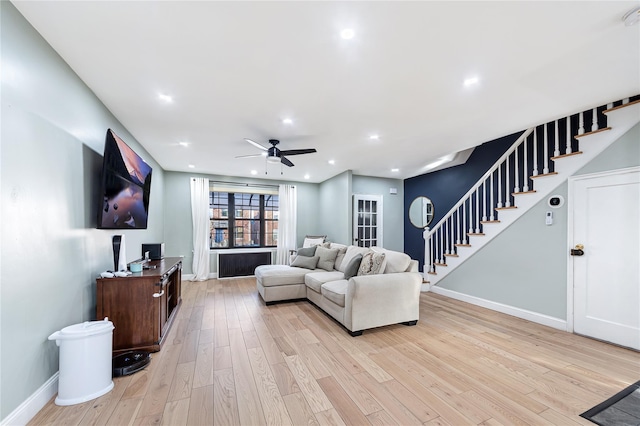 living room featuring ceiling fan and light hardwood / wood-style floors