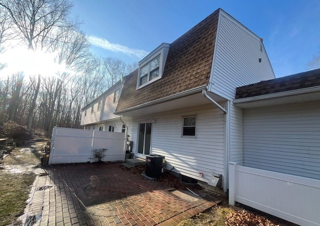 rear view of property with central AC and a patio