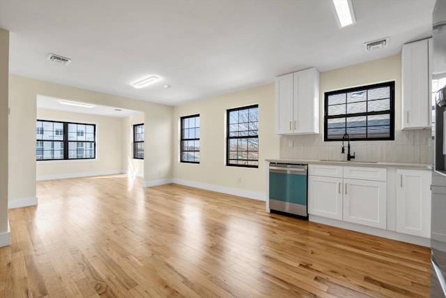 kitchen with white cabinetry, dishwasher, sink, and backsplash