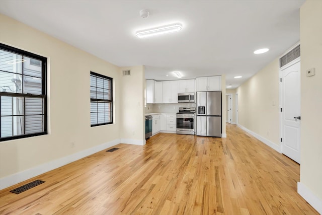 kitchen with white cabinetry, appliances with stainless steel finishes, and light hardwood / wood-style floors