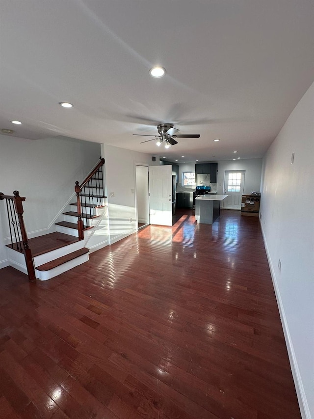 unfurnished living room with dark hardwood / wood-style floors and ceiling fan